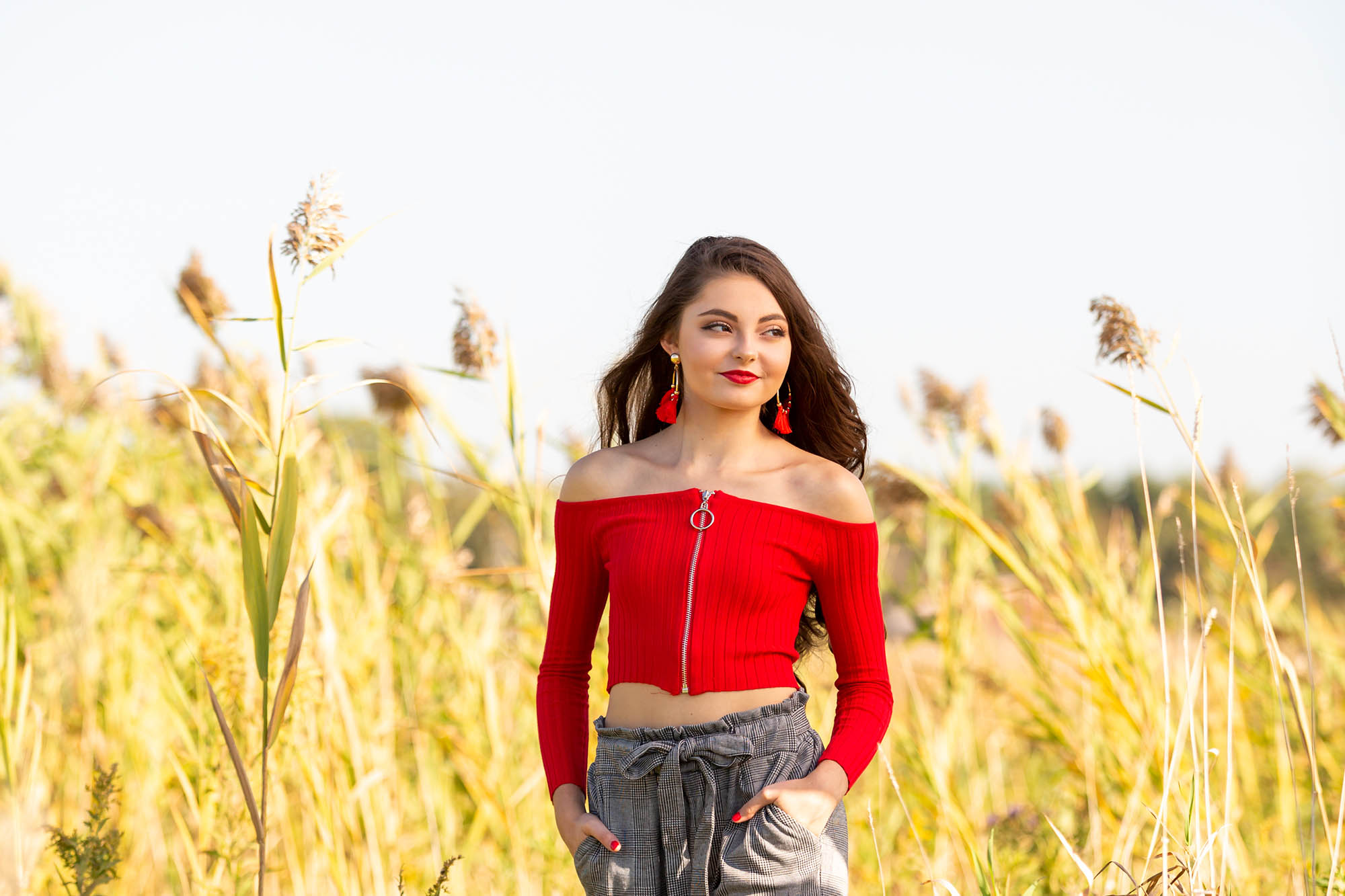 beautiful female caucasain high school senior girl in red crop top sweater 