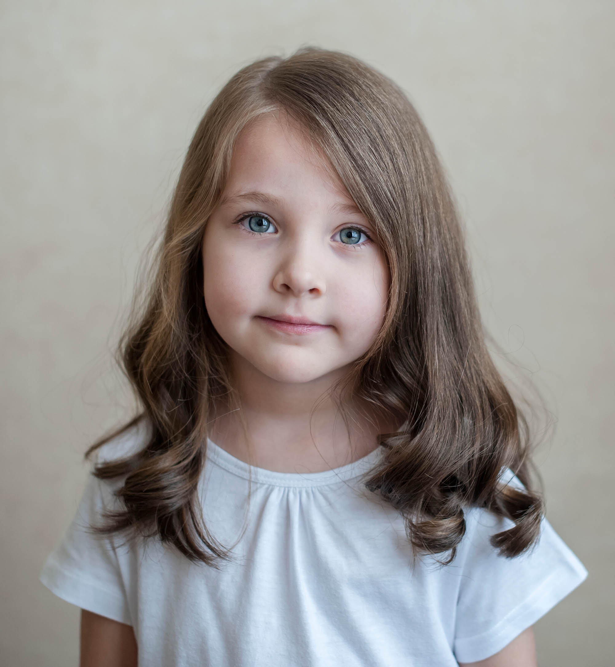 Portrait,Of,Little,Beautiful,Brunette,Girl,Smiling,Looking,At,Camera Portrait of little beautiful brunette girl smiling looking at camera over background